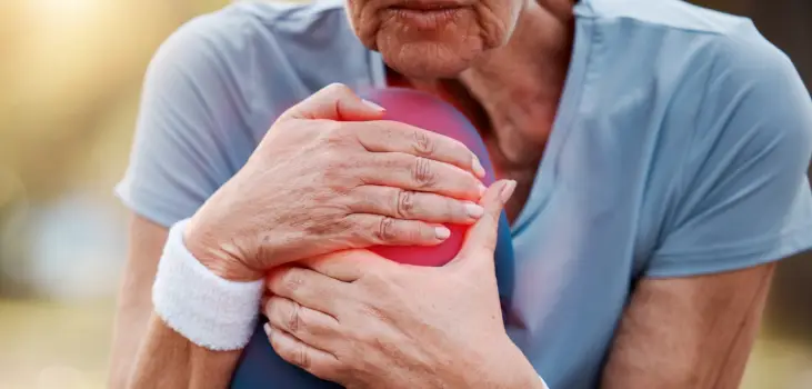 senior woman grabbing her knee which is in pain