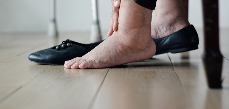 woman with touching her feet hurting